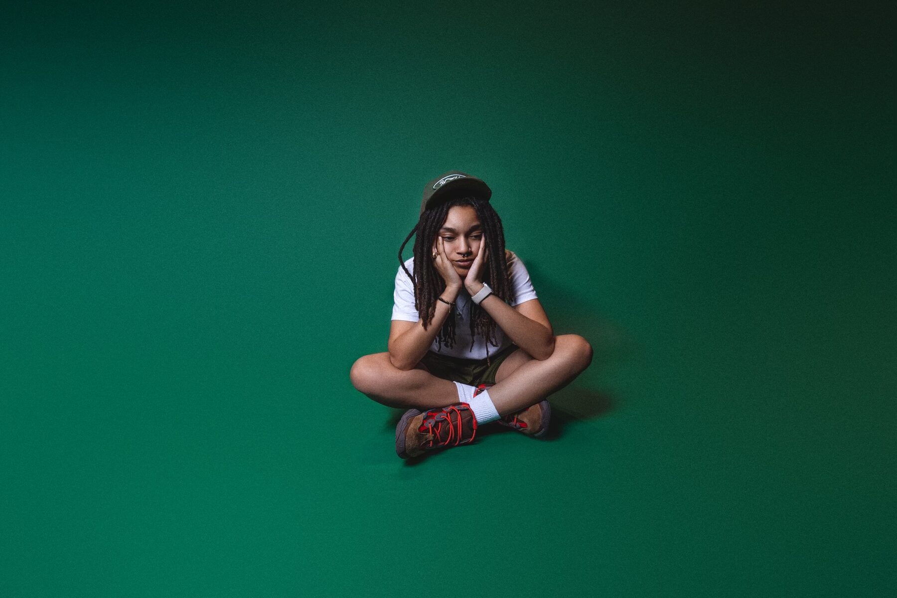 Seated studio portrait against a green backdrop